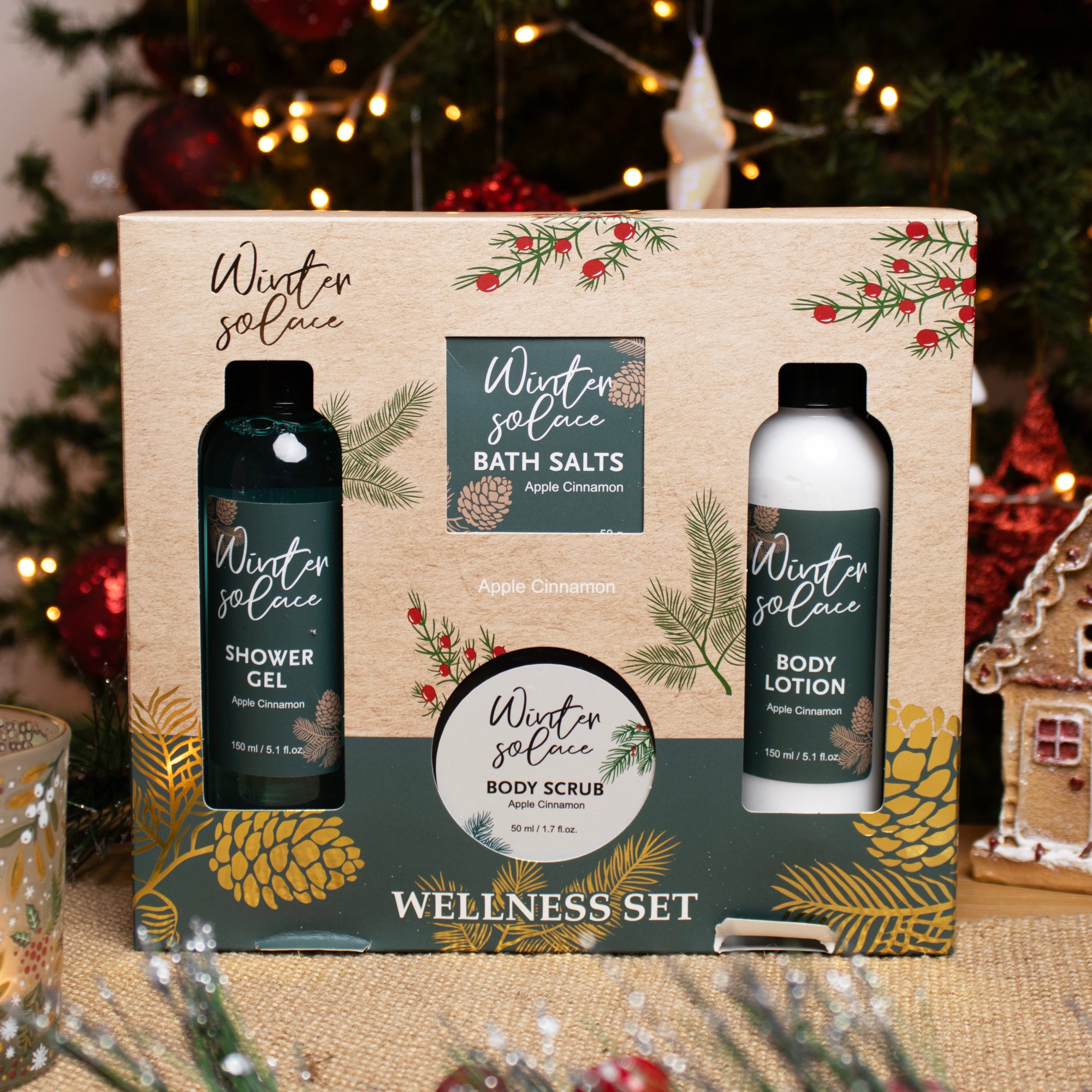 A festive looking 4-piece home spa wellness set with 'Winter Solace' floral design, including bottles of shower gel, body scrub, bath salts, and body lotion, all scented with Apple Cinnamon and gift boxed for Christmas gifting.