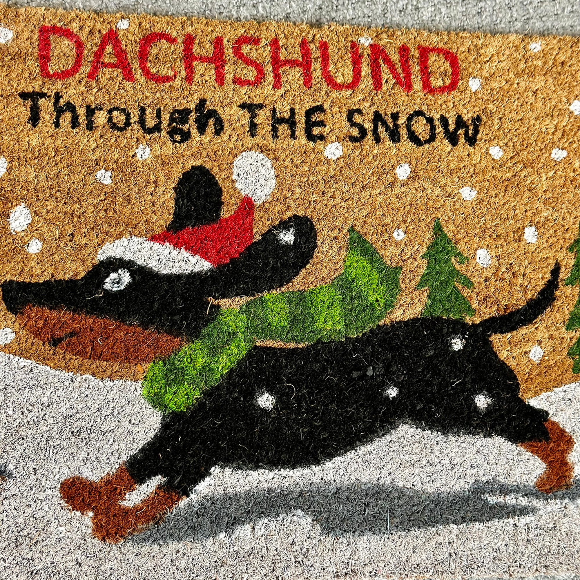 Schwarzer Dackel durch den Schnee Kokosfaser-Fußmatte