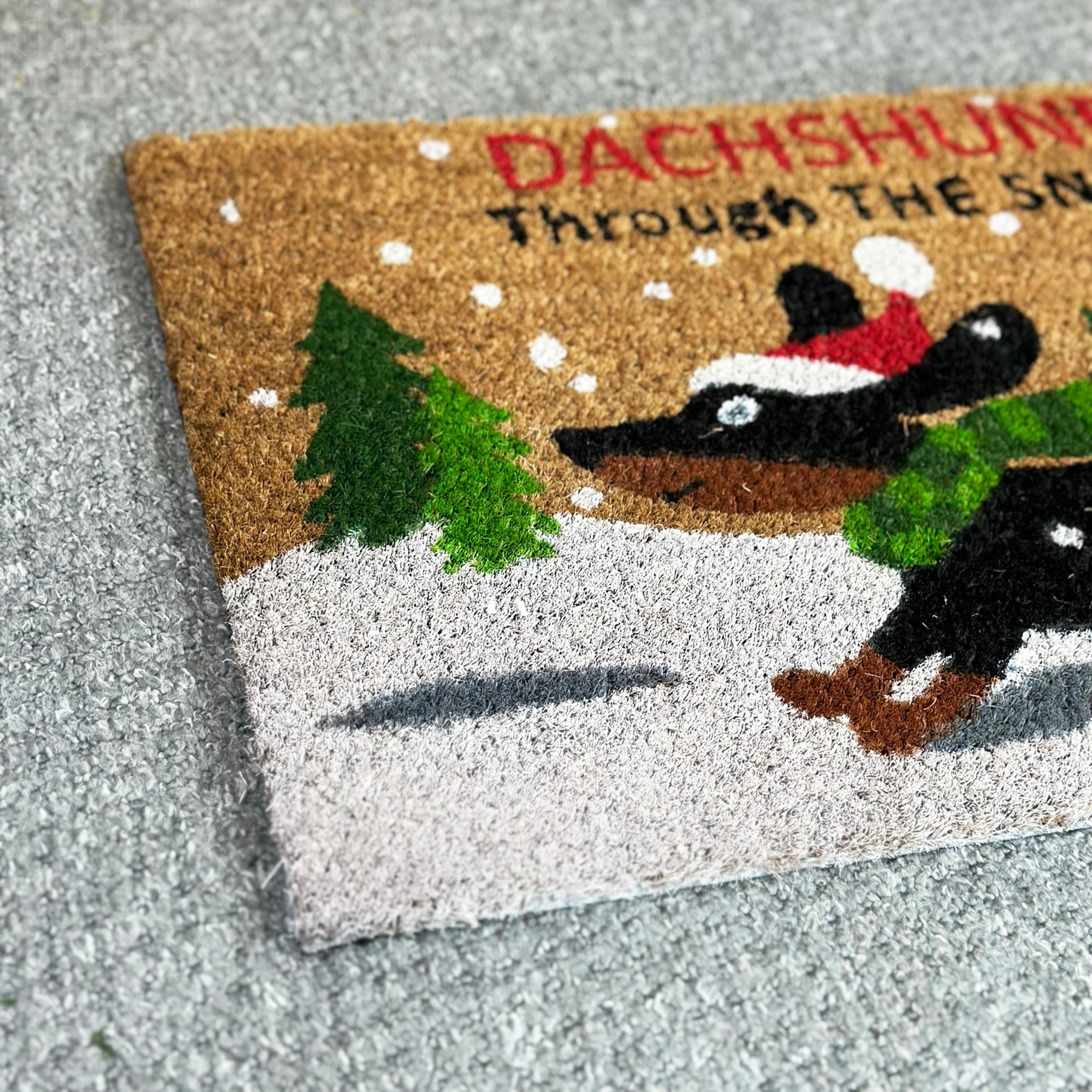 Schwarzer Dackel durch den Schnee Kokosfaser-Fußmatte