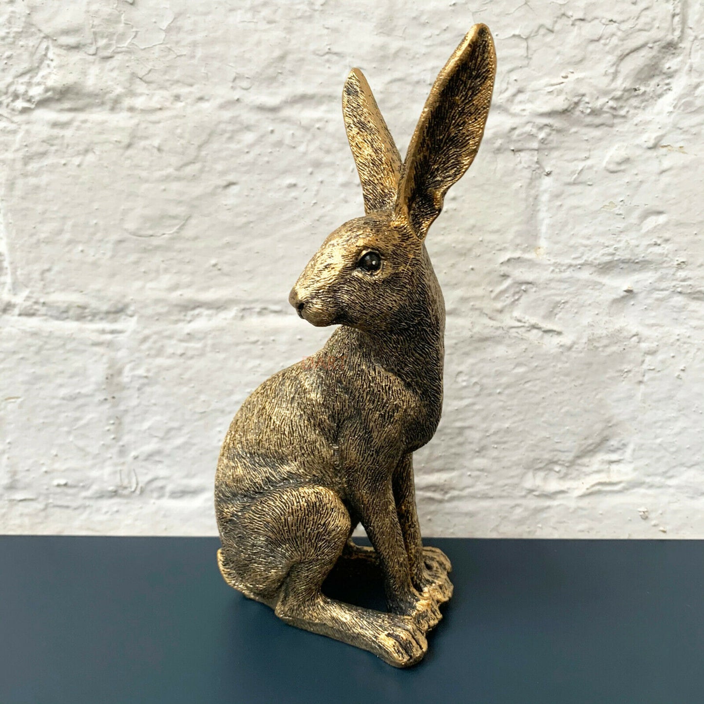 Sitzende Hasenskulptur mit drehendem Kopf aus Kunstharz in Used-Optik