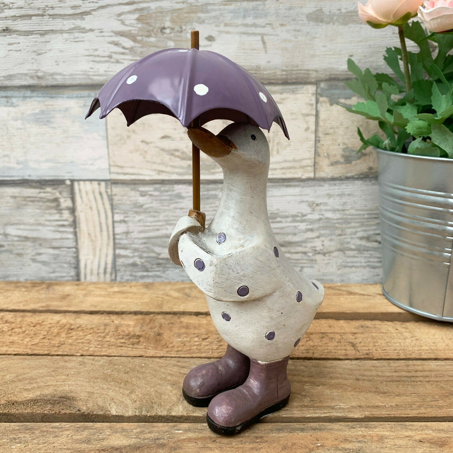 Lila gepunktete Ente mit Regenschirm