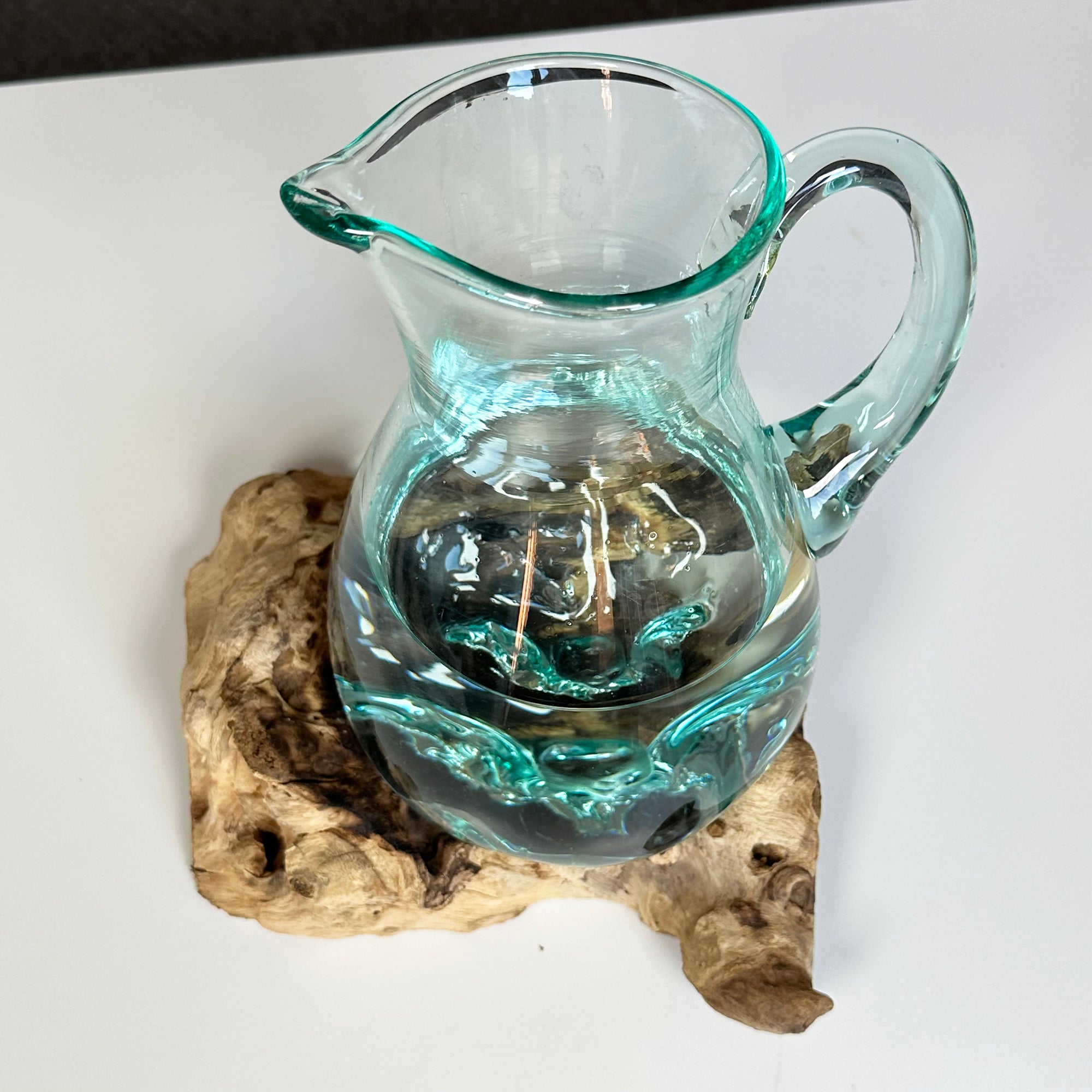 Geschmolzener Krug auf Teakholz-Wurzelständer