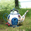 Decorative teapot-shaped fairy house on grass