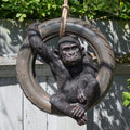 Gorilla figure sitting in a tyre swing with greenery in the background