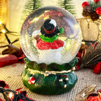 Snowman In Green Sack Snow Globe