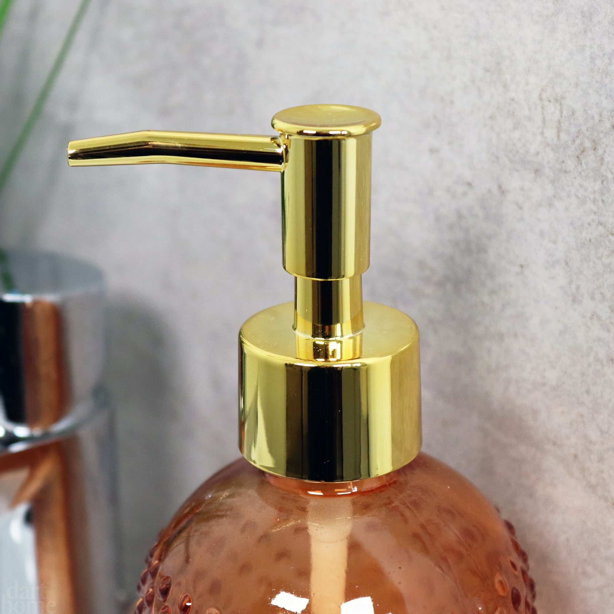 Orangefarbener Seifenspender aus Glas