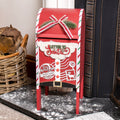 A red Christmas themed mailbox with a 'Letter to Santa' sign, adorned with a red and white Christmas bow, real dried flowers, Santa Claus North Pole, and a reindeer stamp decoration.