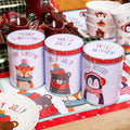 Set of 3 winter-themed storage tins with airtight lids, featuring holiday-inspired designs such as a fox, bear, and penguin, in a festive kitchen setting.