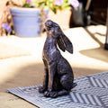 Statue of a bronze effect resin moongazing hare in a garden patio setting