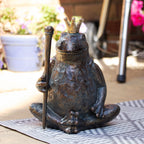 Bronze frog statue with a gold royal crown and scepter on a garden patio setting