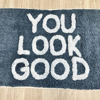 Blaue Badematte „You Look Good“.