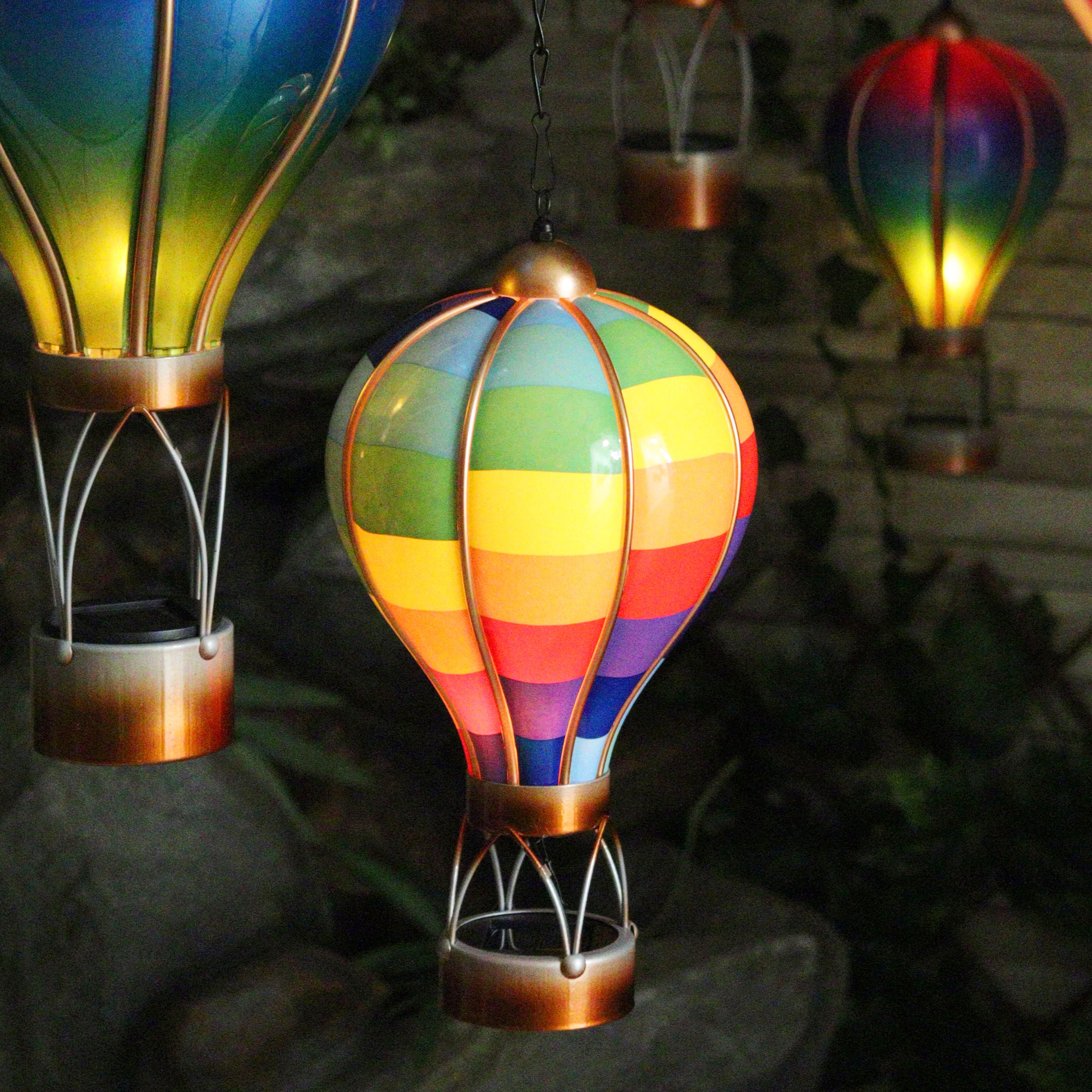Colourful hot air balloon-shaped solar lights hanging outdoors.