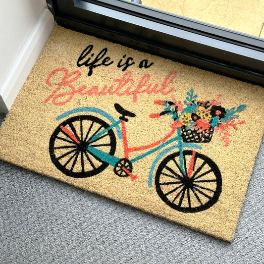 Fußmatte aus Kokosfaser mit Schriftzug „Life Is Beautiful“.
