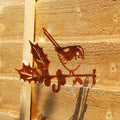 A copper effect steel bird feeder hanger shaped like a perched robin, mounted on a wooden fence.