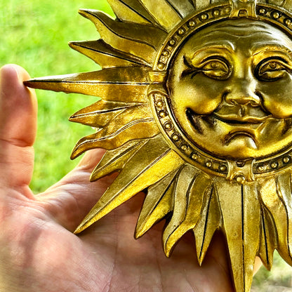 Goldfarbenes Wandschild mit lächelnder Sonne