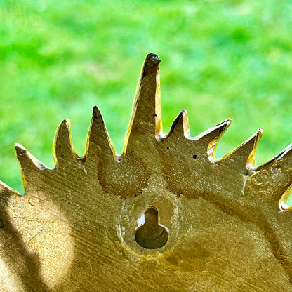 Goldfarbenes Wandschild mit lächelnder Sonne