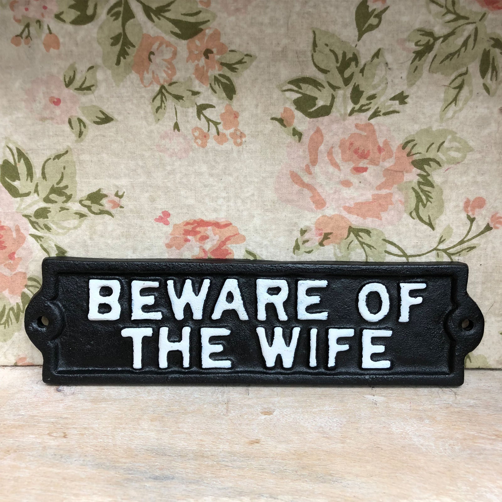 Schwarzes Gusseisenschild „Vorsicht vor der Frau“.