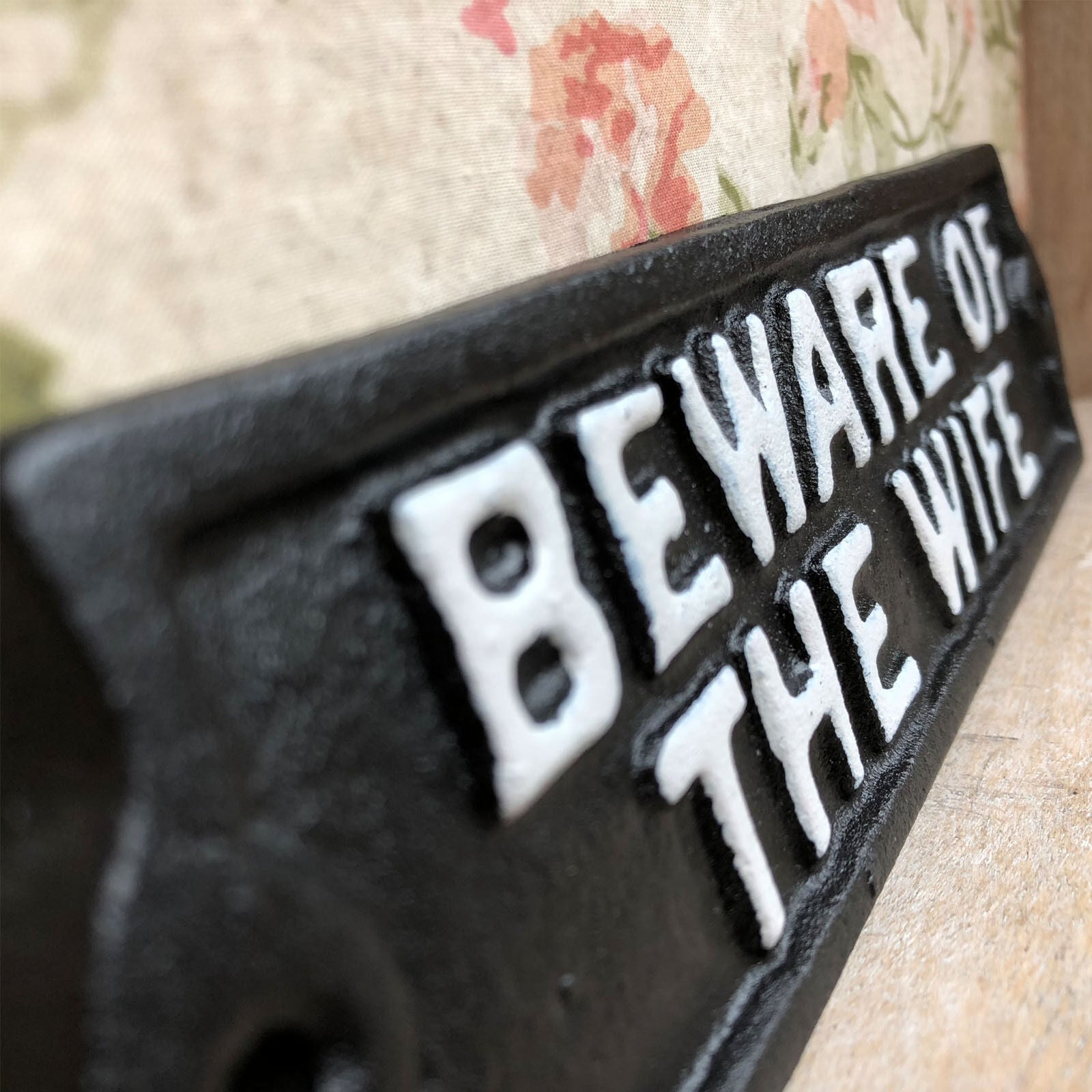 Schwarzes Gusseisenschild „Vorsicht vor der Frau“.