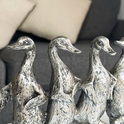 Silberne Skulptur mit fünf tanzenden Enten