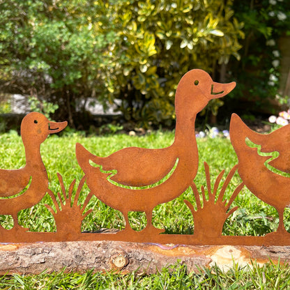 Rostige Enten-Gartendekoration auf Holzständer
