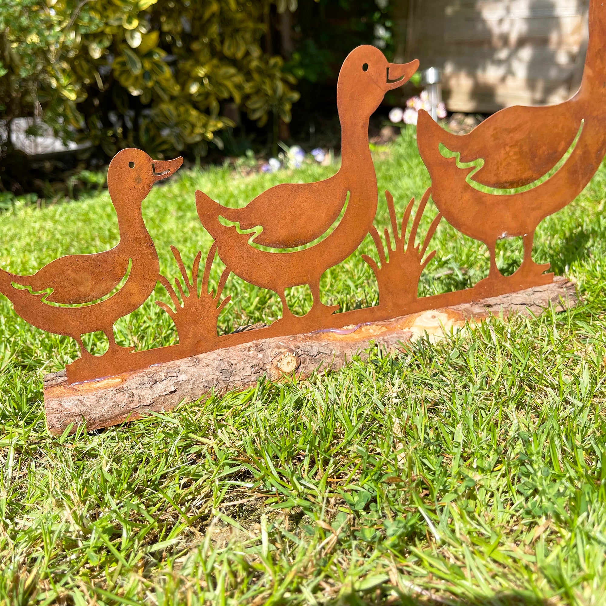 Rostige Enten-Gartendekoration auf Holzständer