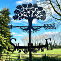 A black silhouette weathervane featuring a tree design with a directional arrow and compass points.