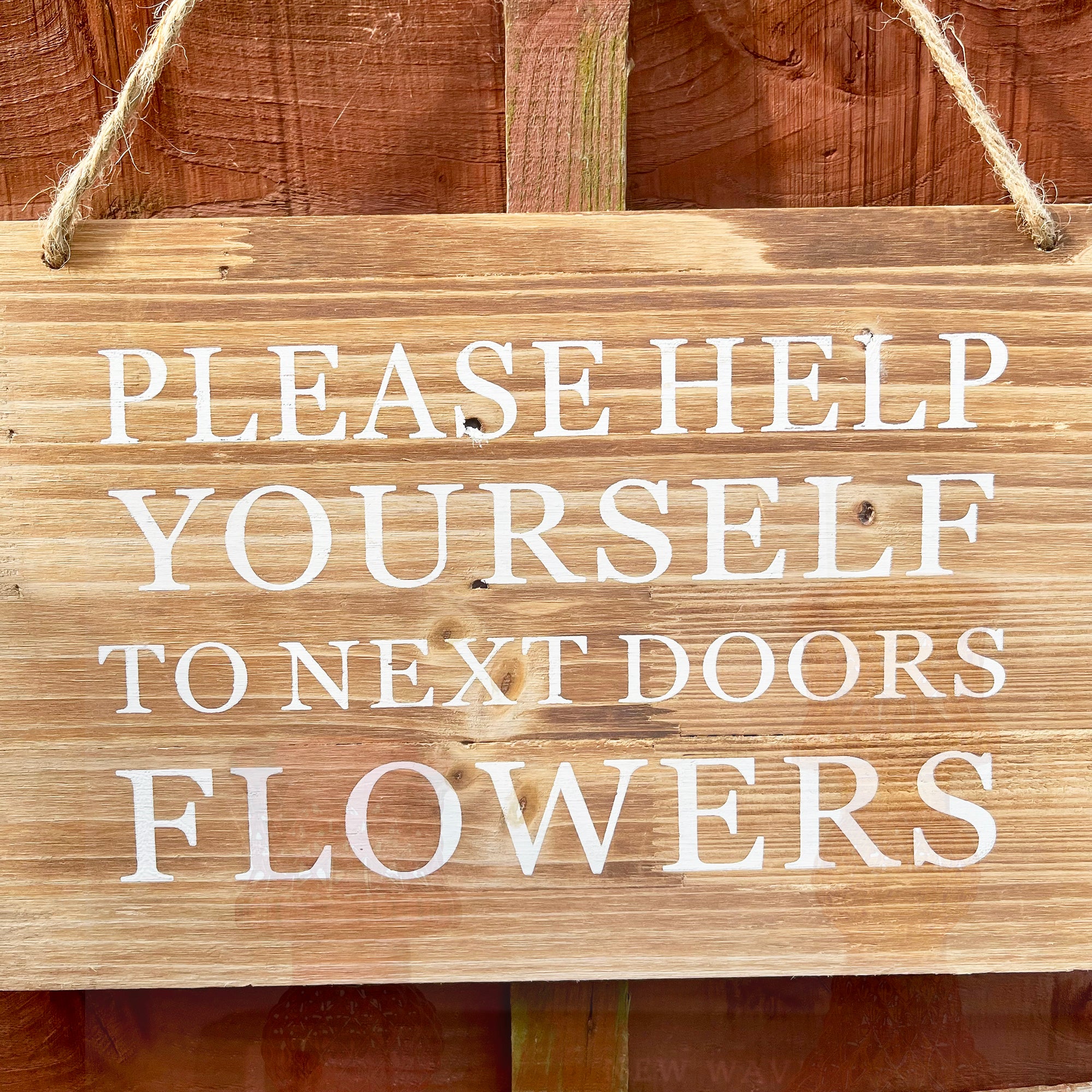 Gartenschild aus Holz – „Help Yourself to Next Doors Flowers“.