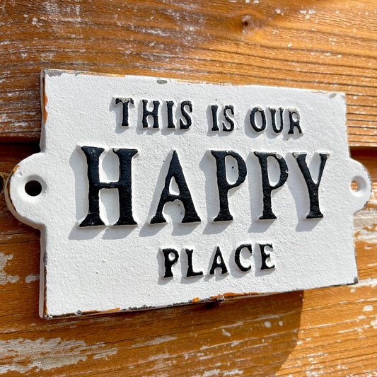 Weißes Gusseisen-Schild „This Is Our Happy Place“.