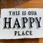 Weißes Gusseisen-Schild „This Is Our Happy Place“.