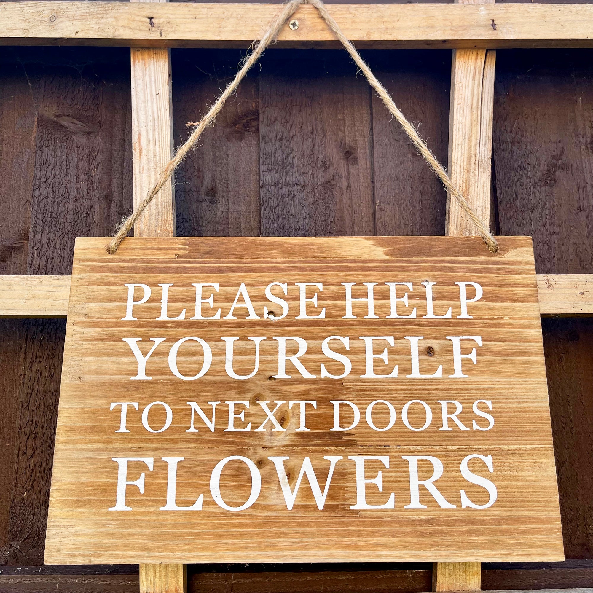 Gartenschild aus Holz – „Help Yourself to Next Doors Flowers“.