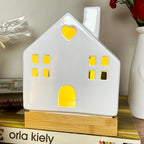 Leuchtende Keramik-Hausornamente mit Holzsockel