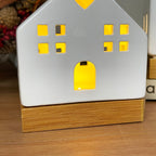 Leuchtende Keramik-Hausornamente mit Holzsockel