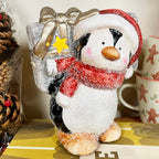 Leuchtende Pinguinfigur mit Geschenk