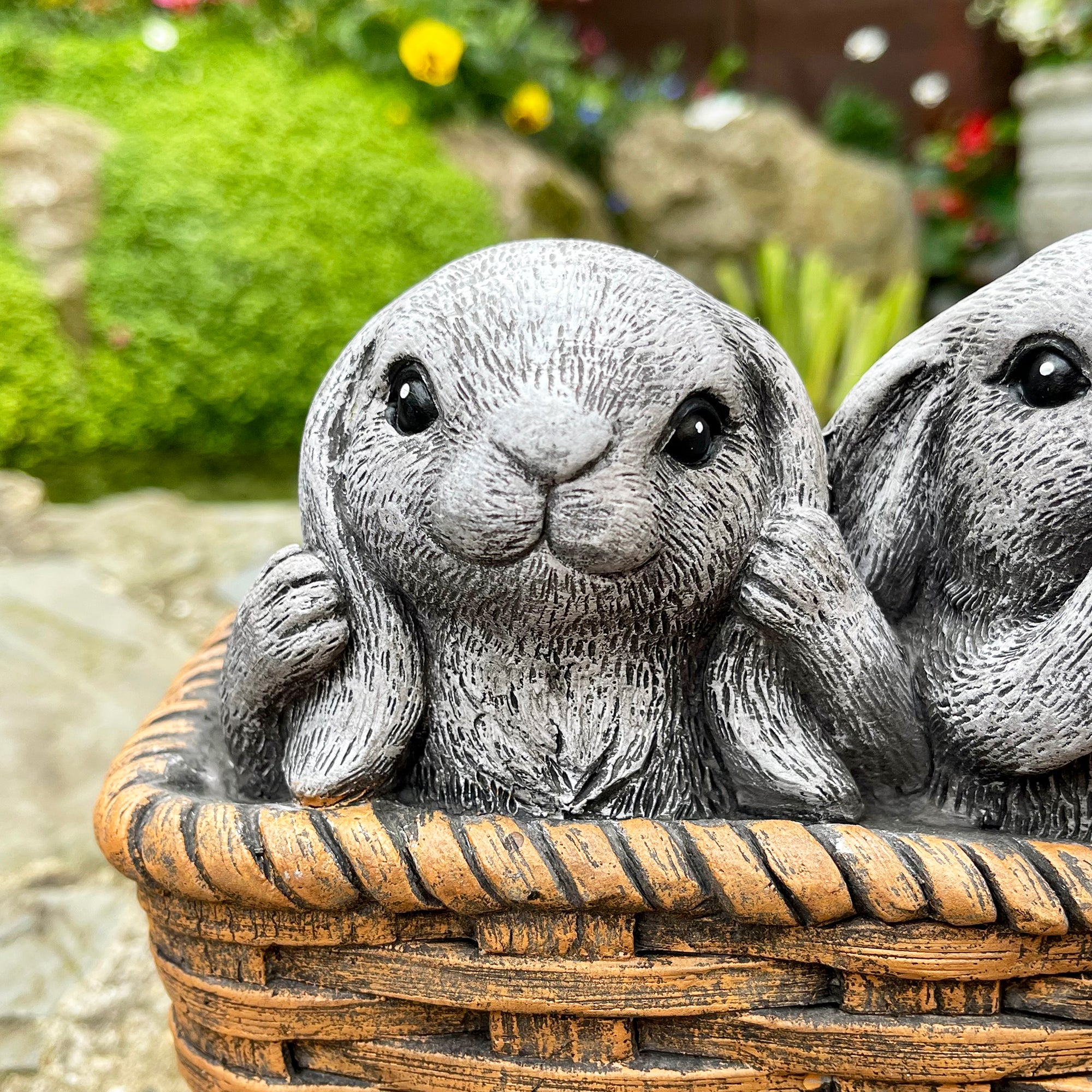 Drei weise Kaninchen im Pflanzgefäß aus Zement
