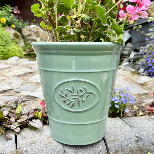 A green, glossy ceramic effect plastic round planter pot with embossed leaf detailing.