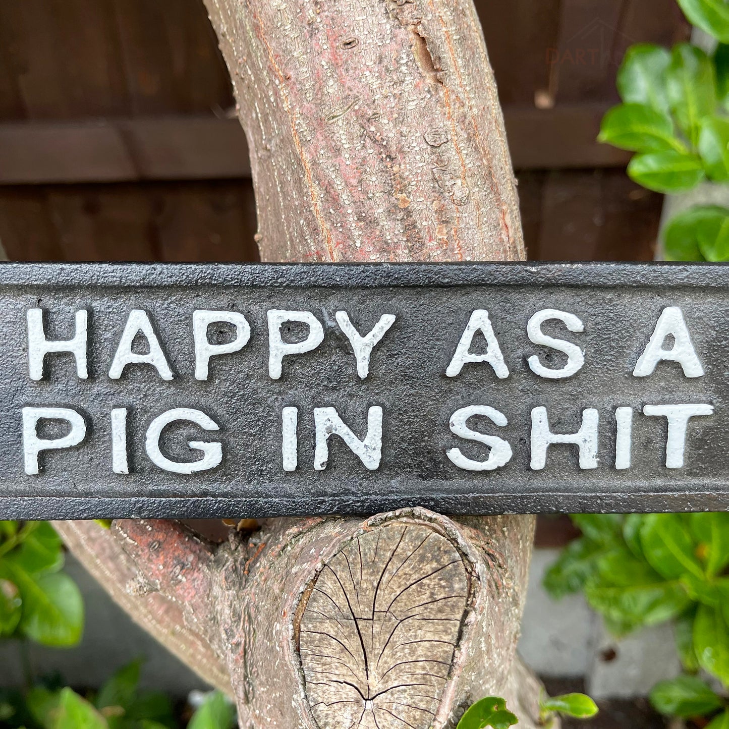 Schwarzes Gusseisenschild „Happy As A Pig In Sh#t“.