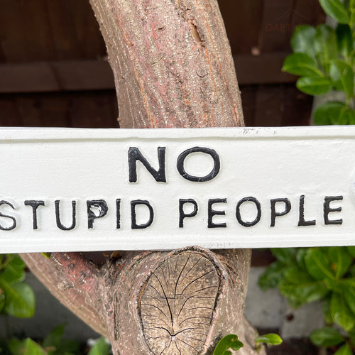 Weißes Gusseisen-Schild „Keine dummen Leute“.