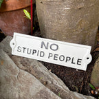 Weißes Gusseisen-Schild „Keine dummen Leute“.