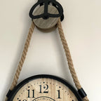 Hängende Uhr an Seilrolle
